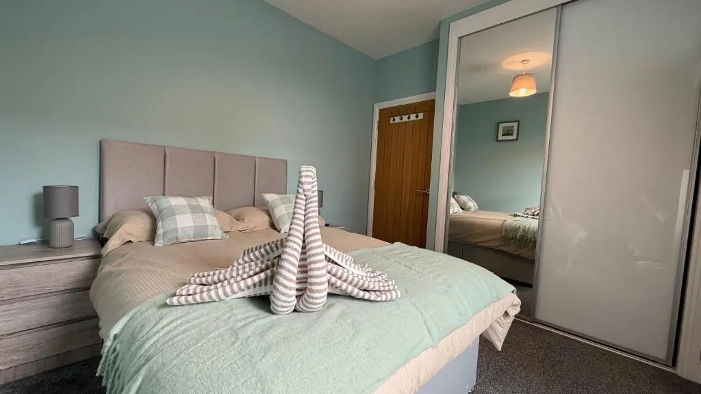 a bedroom with a bed with a stuffed animal on it at The Bakehouse - by Caithness Luxury Apartments NC500 - 5 Bedroom Luxury Holiday Home - Sleeps Work teams upto 5 & holiday makers upto 10 in Wick