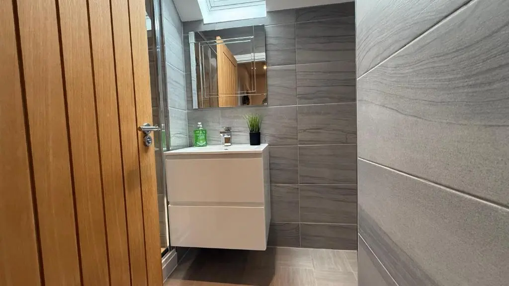 a bathroom with a sink and a mirror at The Bakehouse - by Caithness Luxury Apartments NC500 - 5 Bedroom Luxury Holiday Home - Sleeps Work teams upto 5 & holiday makers upto 10 in Wick