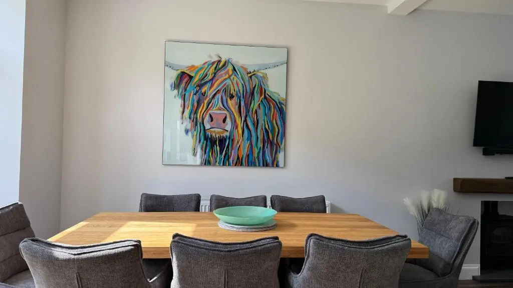 a dining room table with a painting of a tiger at The Bakehouse - by Caithness Luxury Apartments NC500 - 5 Bedroom Luxury Holiday Home - Sleeps Work teams upto 5 & holiday makers upto 10 in Wick