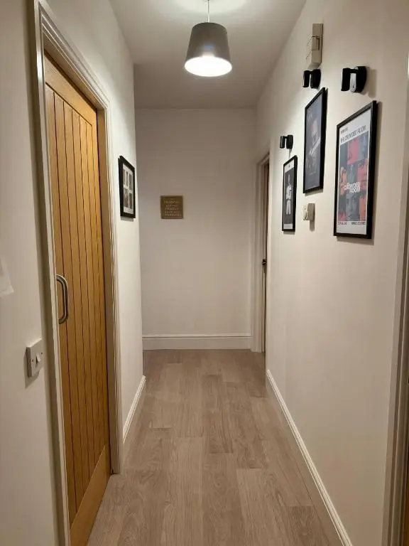 a hallway with a door and pictures on the wall at The Willows in Nairn