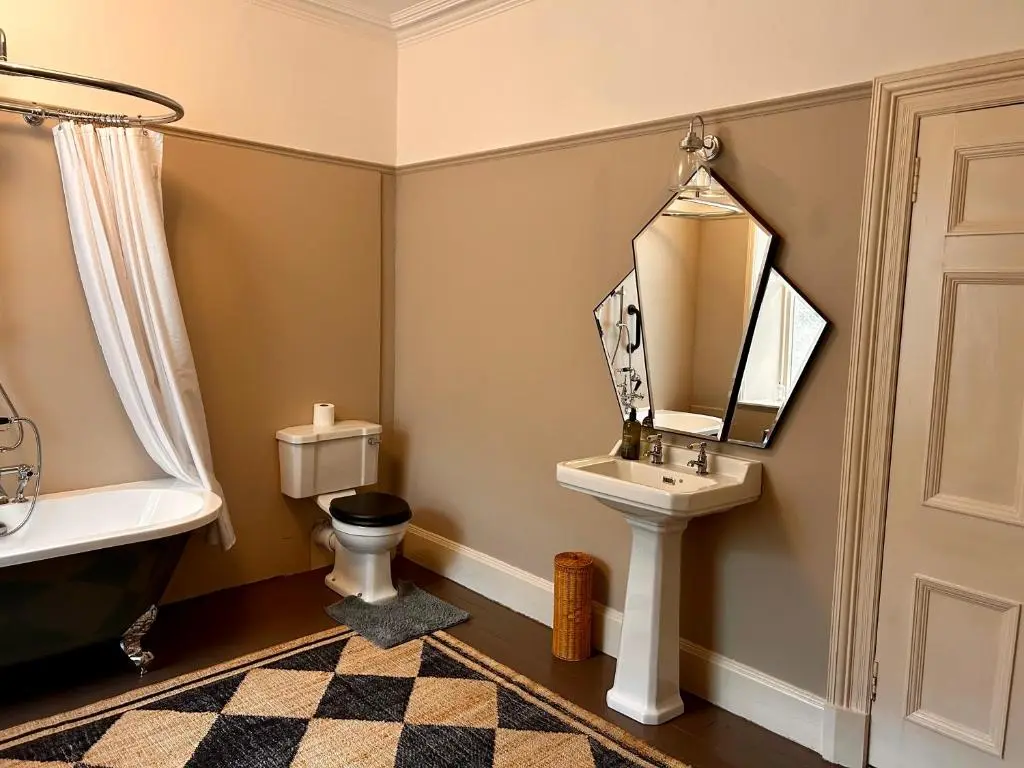 a bathroom with a sink and a toilet and a mirror at Clashmore House in Dornoch