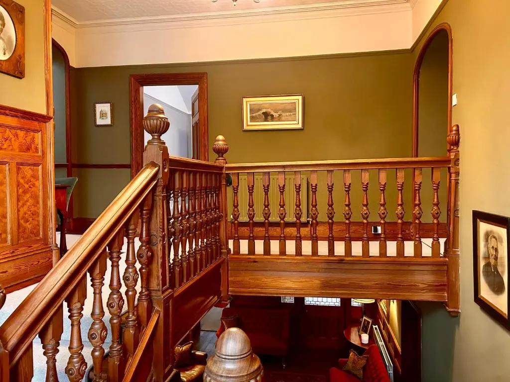 a wooden staircase in a home with green walls at Clashmore House in Dornoch
