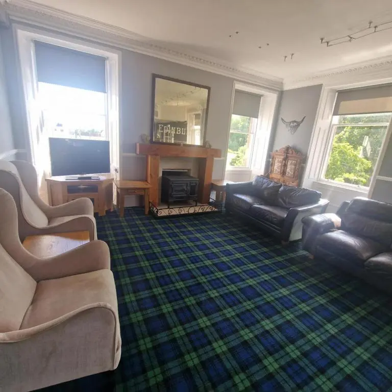 a living room with two couches and a television at Black Isle Holiday Apartments Avoch in Avoch