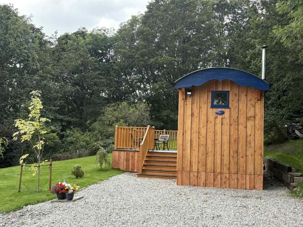 a small wooden out house with a porch and stairs at Shepherd's Bothy, Bothan a Bhuachaille, Black Isle in Munlochy