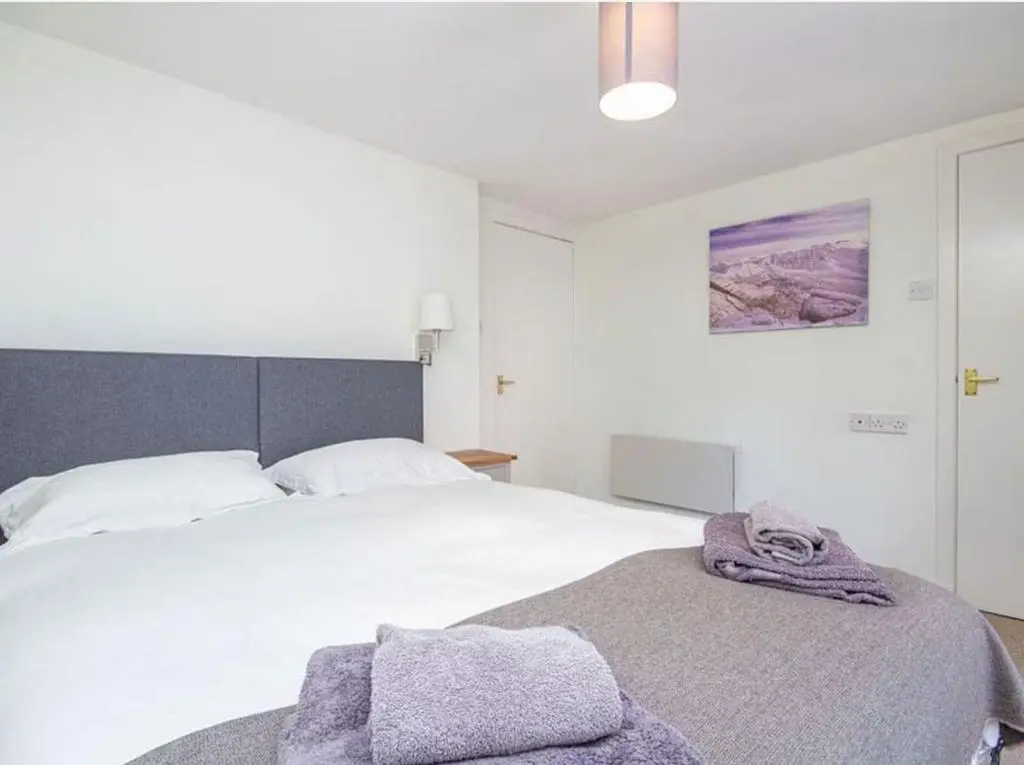 a bedroom with a bed with two towels on it at 1 Bedroom Alexander Cottage-Free Parking in Inverness