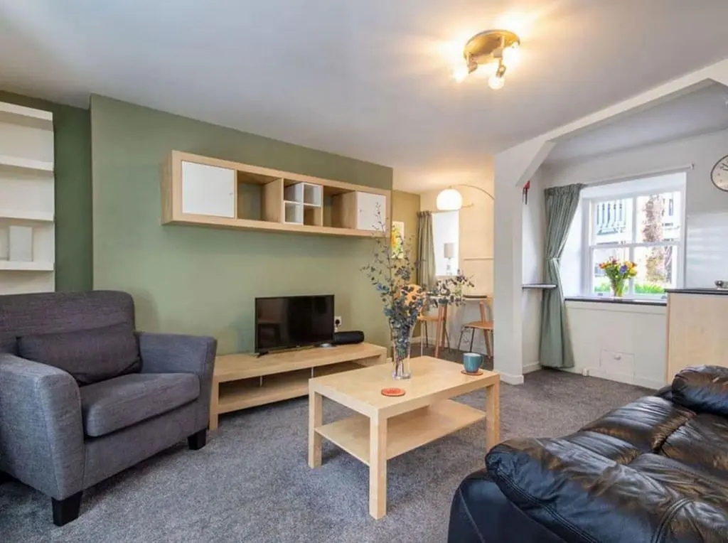 a living room with a couch and a tv at 1 Bedroom Alexander Cottage-Free Parking in Inverness