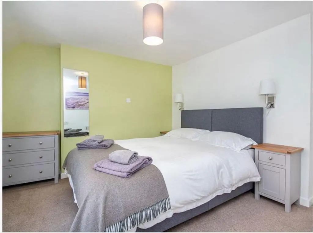 a bedroom with a large bed with towels on it at 1 Bedroom Alexander Cottage-Free Parking in Inverness