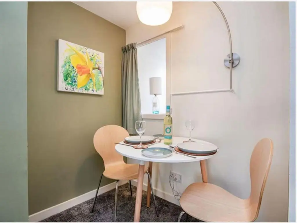 a small table with two chairs and a bottle of wine at 1 Bedroom Alexander Cottage-Free Parking in Inverness
