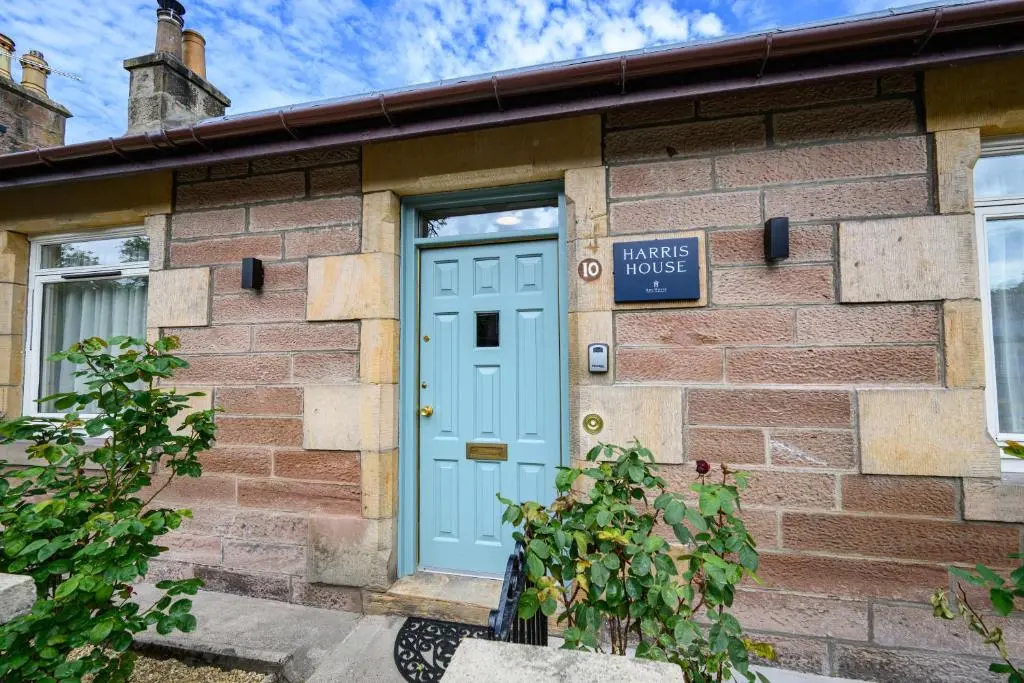 a brick building with a blue door at Harris House in Inverness