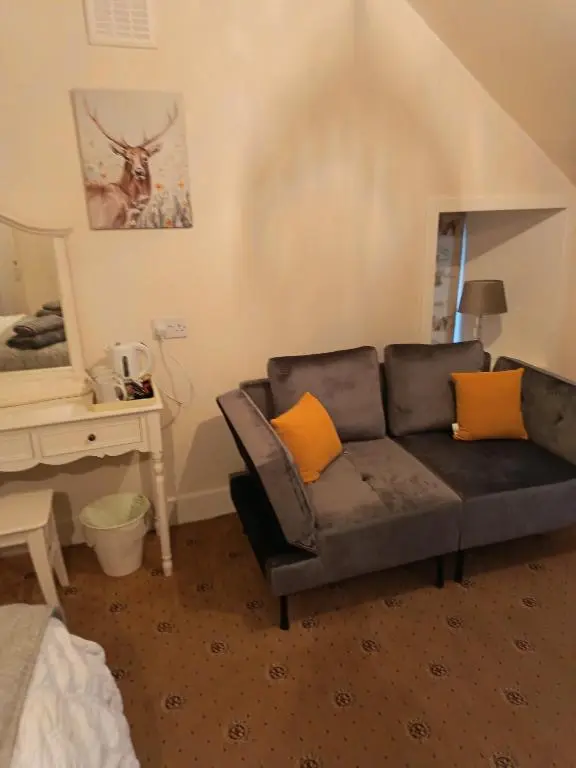 a living room with a couch and a desk at River Black Water inn in Garve