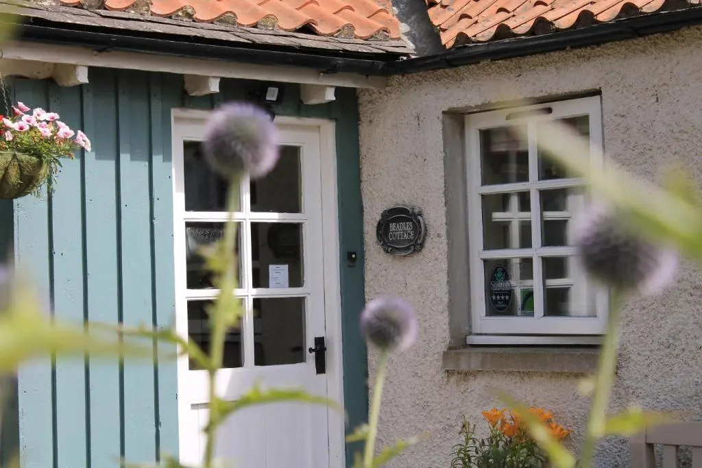 a house with a white door and a window at St Brandon House Country Cottages in Boyndie