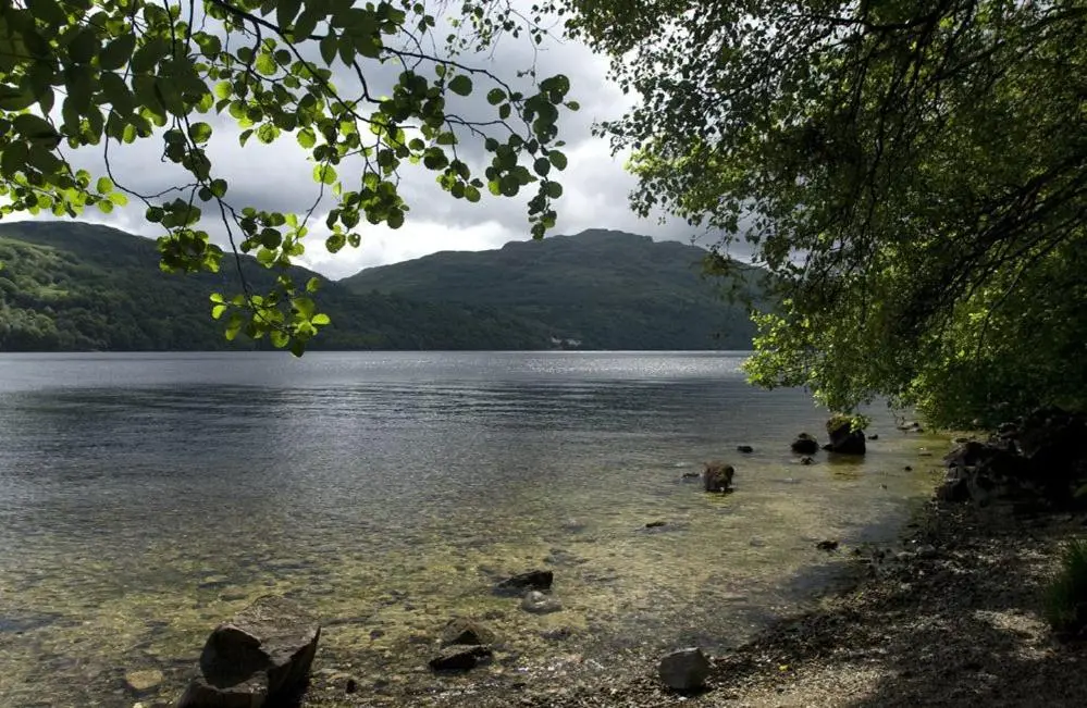 a view of a lake with mountains in the background at Biallid House in Newtonmore