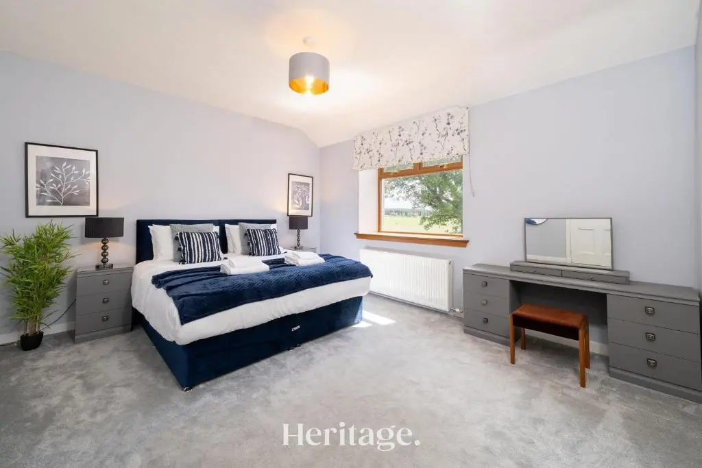 a bedroom with a blue bed and a television at Woodside, Get away with Hot Tub, near Fraserburgh in Strichen