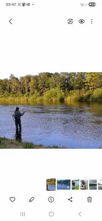 a man is standing in a river holding a rod at Mary Cottage in Garmouth