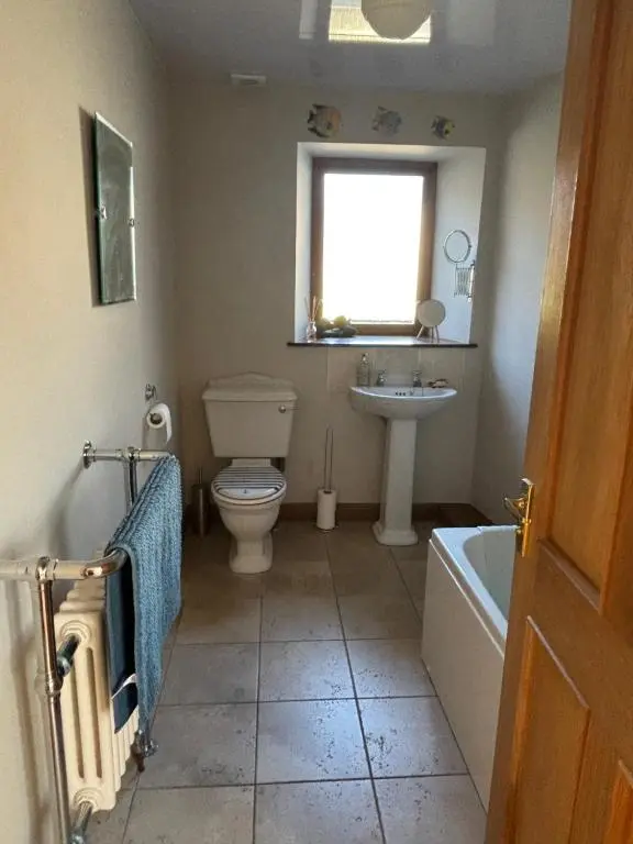 a bathroom with a toilet and a sink and a tub at Mary Cottage in Garmouth