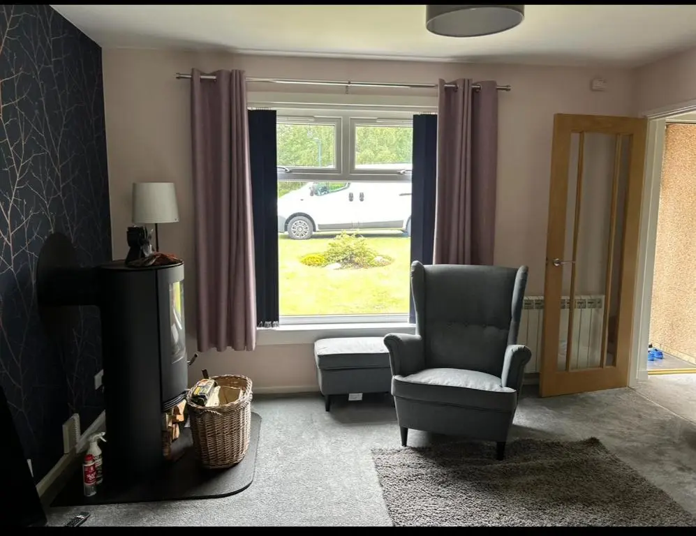 a living room with a chair and a window at 6 Carn Dearg House in Aviemore