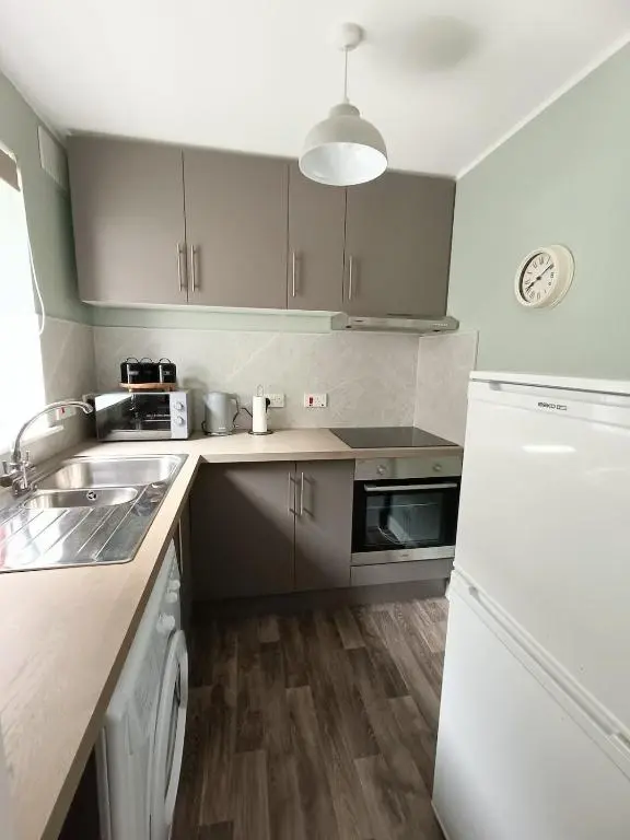a kitchen with a white refrigerator and a sink at Central City Apartment - Inverness centre in Inverness