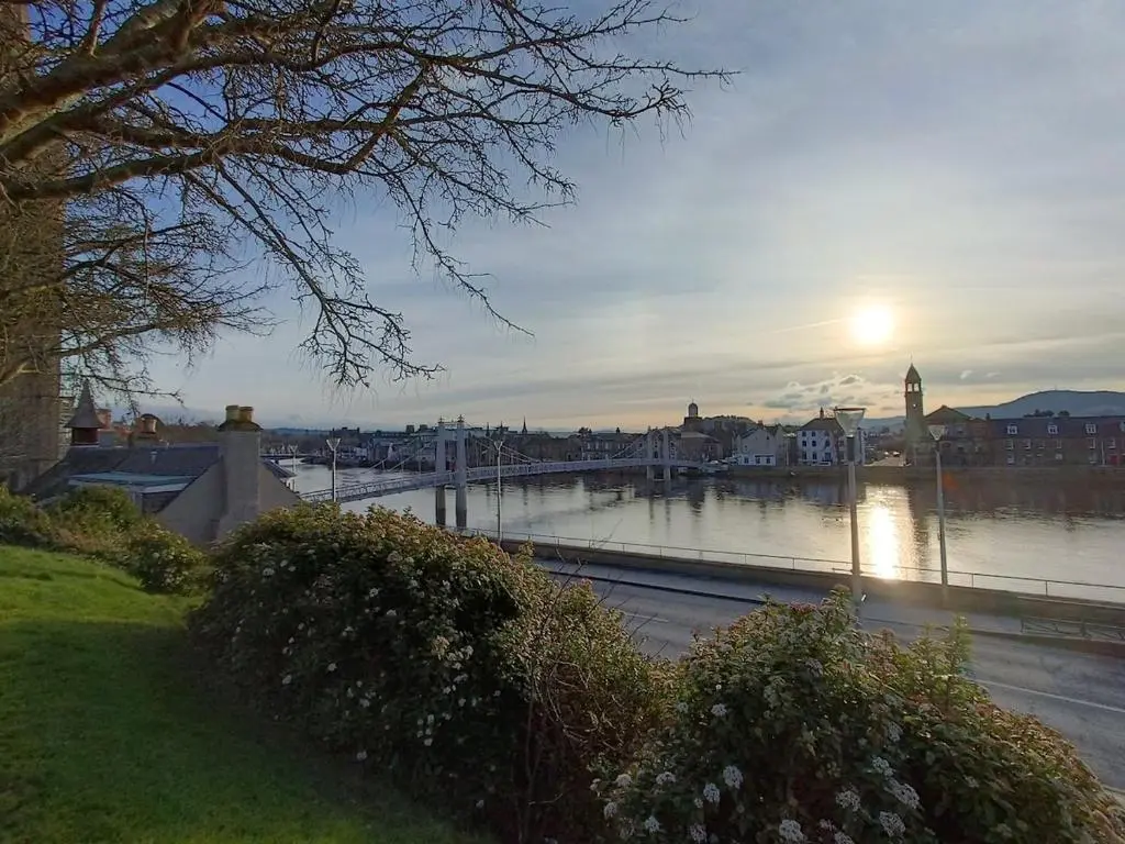 a view of a river with a bridge and a city at Central City Apartment - Inverness centre in Inverness