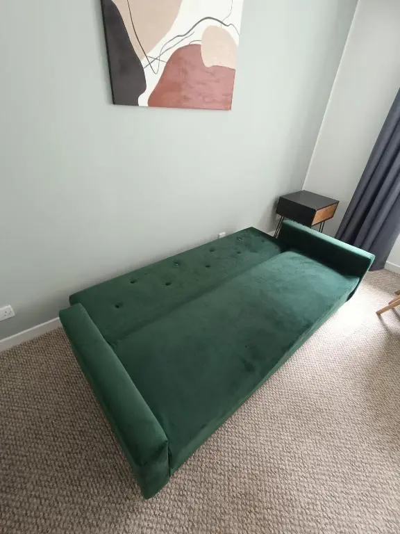 a green bed in a corner of a room at Central City Apartment - Inverness centre in Inverness