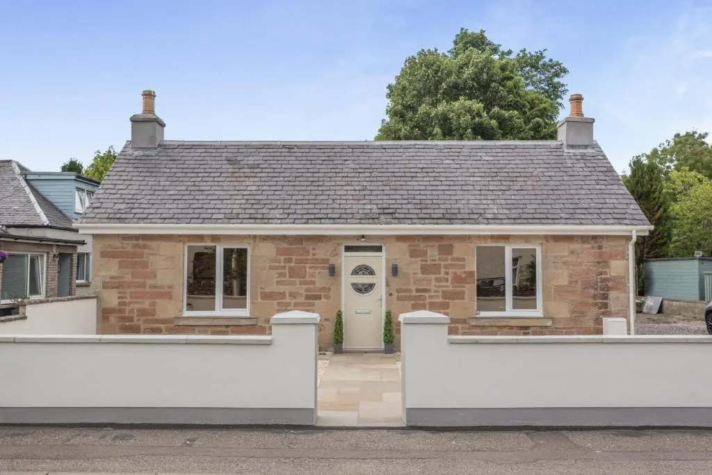 a brick house with a white fence in front of it at 2 Bed in Inverness oc-b32706 in Inverness