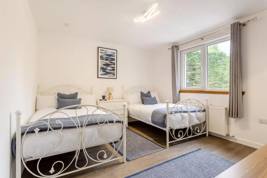 two beds in a white room with a window at 2 Bed in Inverness oc-b32706 in Inverness