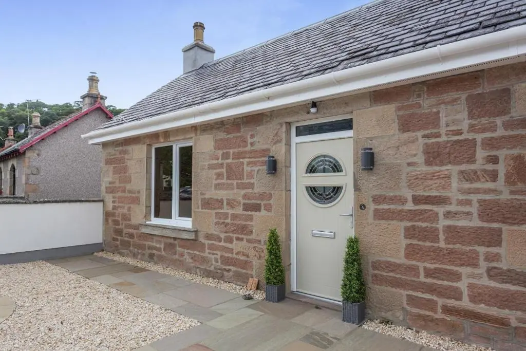 a brick house with a white door and a window at 2 Bed in Inverness oc-b32706 in Inverness