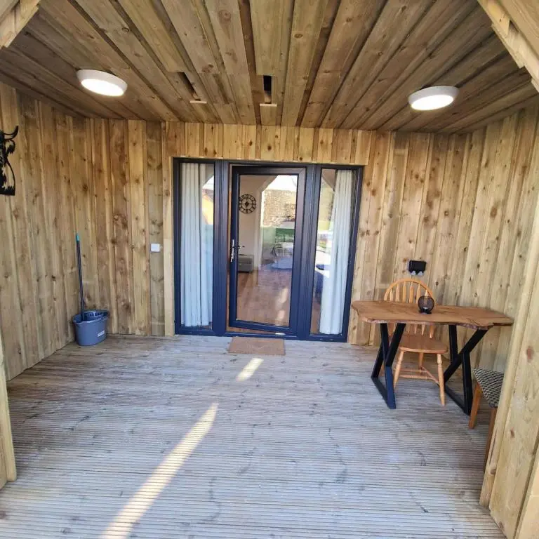 a wooden room with a wooden table and a bench at Temuka Lodge in Glenurguhart