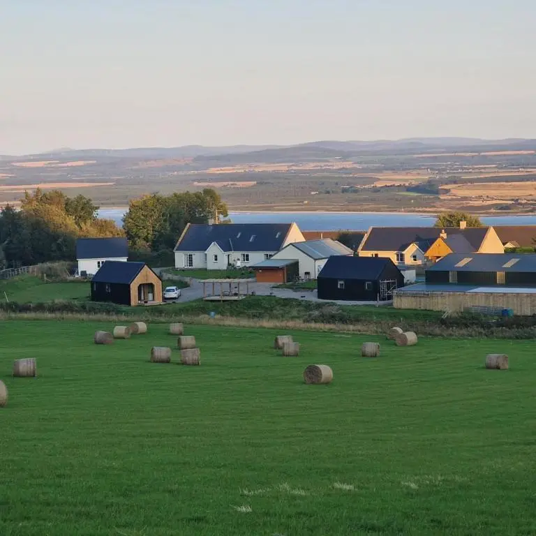 a field with hay bales in a field at Temuka Lodge in Glenurguhart