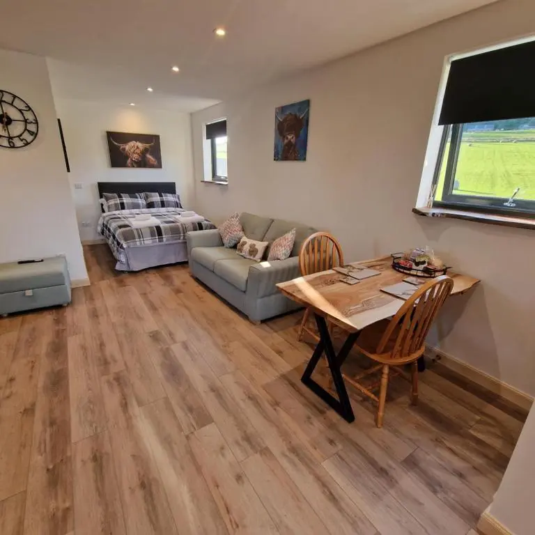 a living room with a couch and a table at Temuka Lodge in Glenurguhart