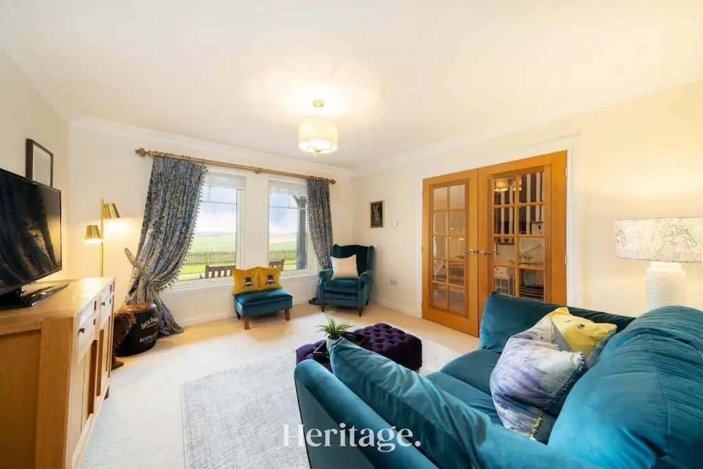a living room with a blue couch and a television at Bonnieview House, Tarves, Aberdeenshire