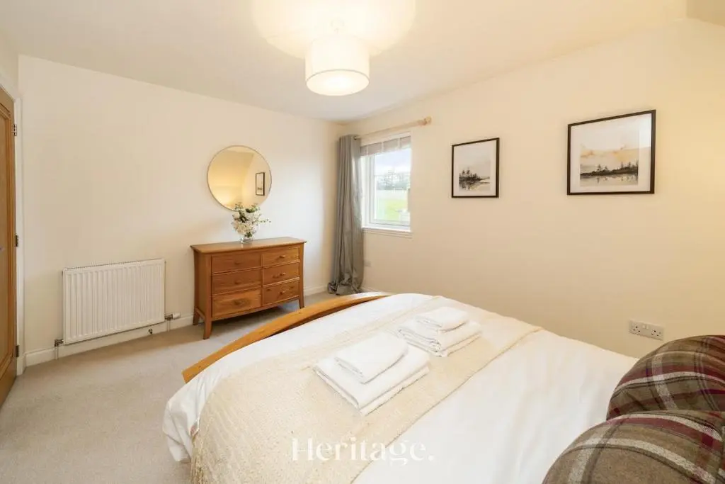 a bedroom with a bed and a mirror on the wall at Bonnieview House, Tarves, Aberdeenshire