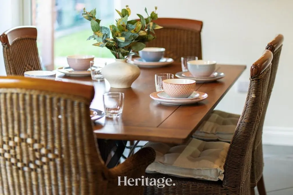 a wooden table with plates and cups and a vase on it at Bonnieview House, Tarves, Aberdeenshire
