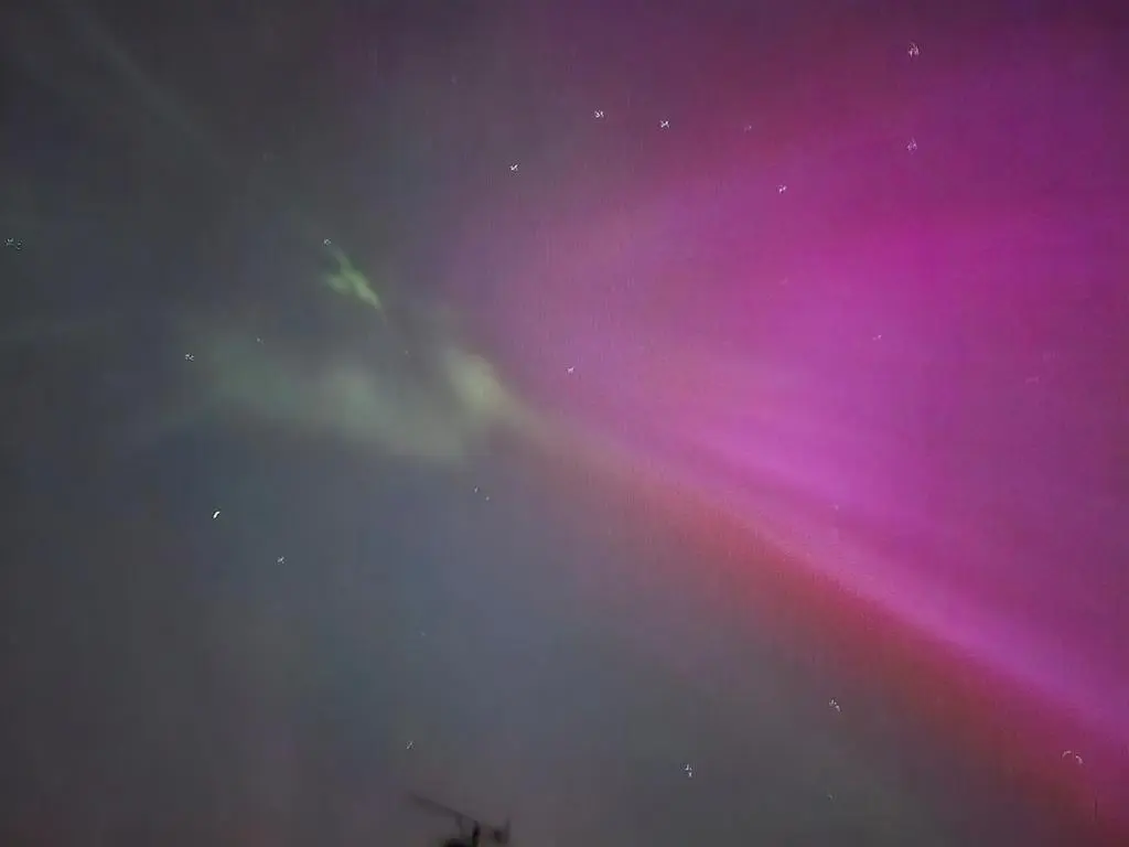 a beam of light in a purple and pink sky at Ghillies Cottage, Loch Ness in Milton