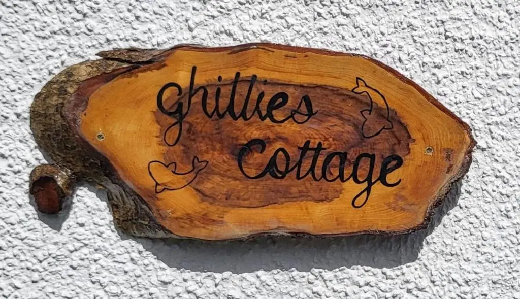 a sign that says solitude is culture on a piece of wood at Ghillies Cottage, Loch Ness in Milton