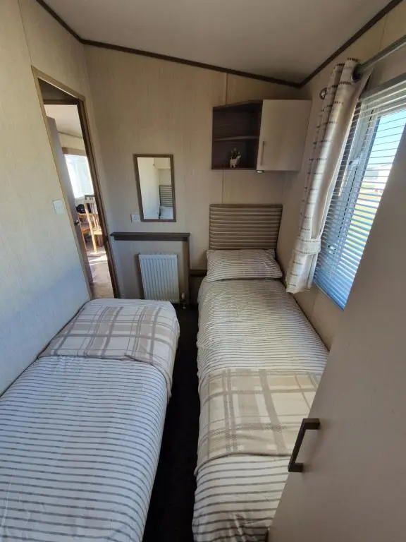 a room with two beds in it with a window at Cladach in Lossiemouth