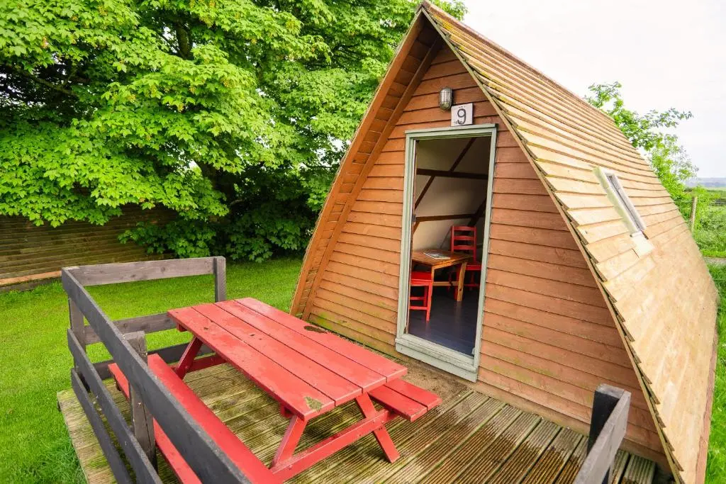 a small tent with a red table and a bench at The Loft Glamping & Camping in Kinloss