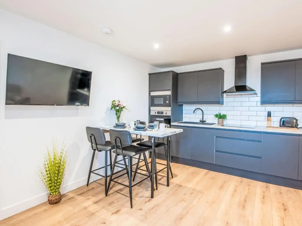 a kitchen with blue cabinets and a table and chairs at Apartment Fishertown Apartment 1st Floor by Interhome in Nairn
