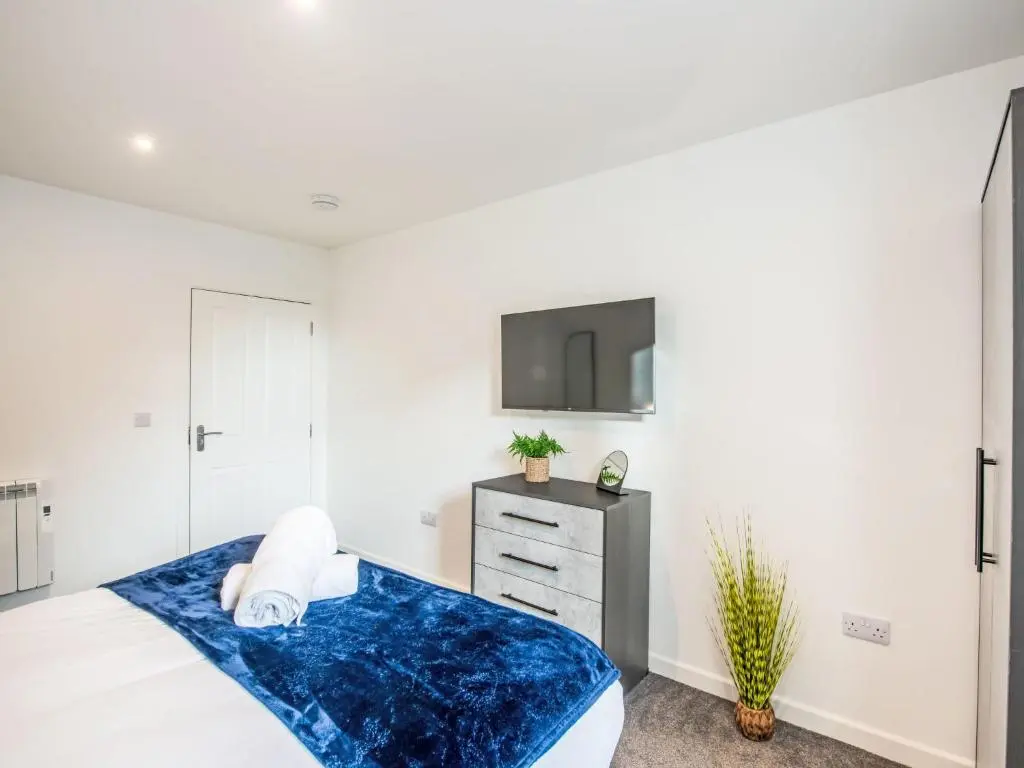 a bedroom with a bed and a tv on a wall at Apartment Fishertown Apartment 1st Floor by Interhome in Nairn