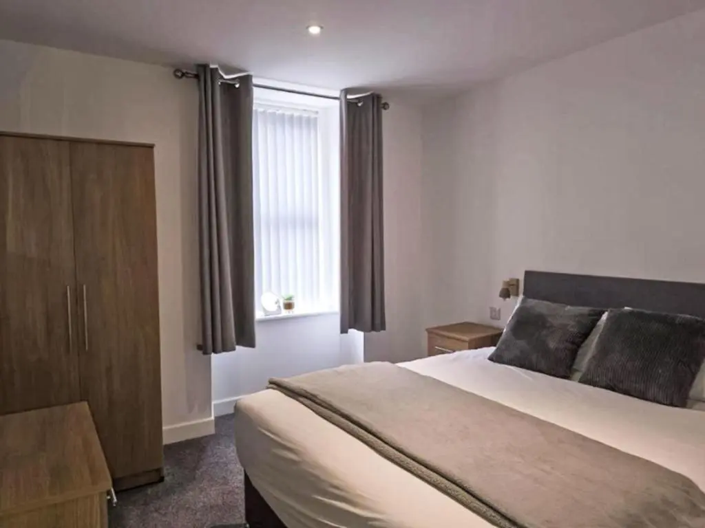 a bedroom with a large bed and a window at Apartment Fishertown Apartment by Interhome in Nairn