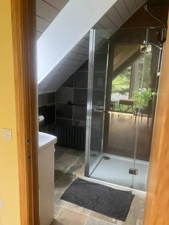 a glass shower in a bathroom with a staircase at Dalvourn West Wing , Farr by Inverness in Tordarroch