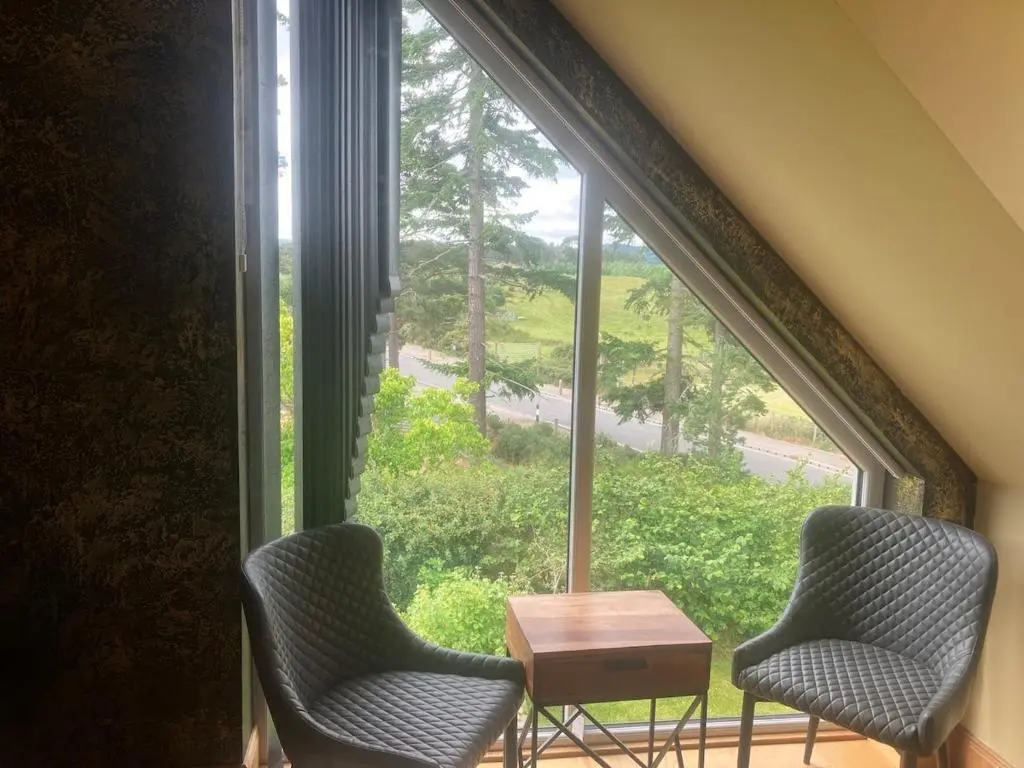 two chairs and a table in front of a window at Dalvourn West Wing , Farr by Inverness in Tordarroch