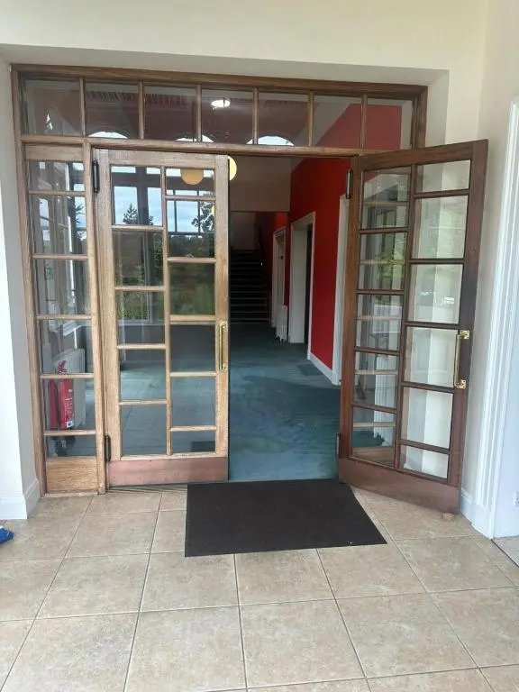 an open door of a building with glass doors at Cluny Hill Hotel in Forres