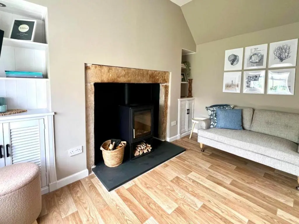 a living room with a fireplace and a couch at Seatown Cottage - Stone's throw from beach in Lossiemouth