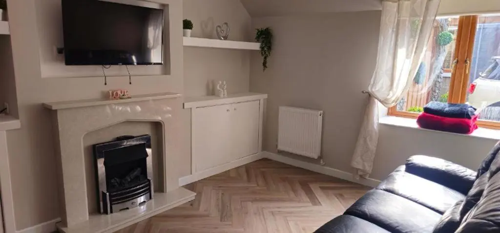 a living room with a fireplace and a flat screen tv at Coastal Bliss, Rosehearty, Fraserburgh in Rosehearty
