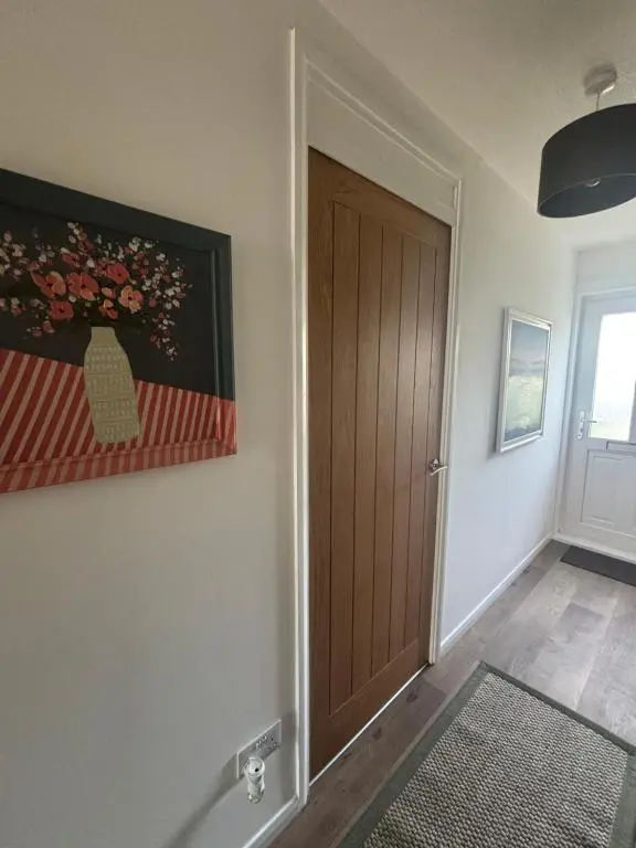 a hallway with a door and a painting on the wall at Number Sixteen in Kildary