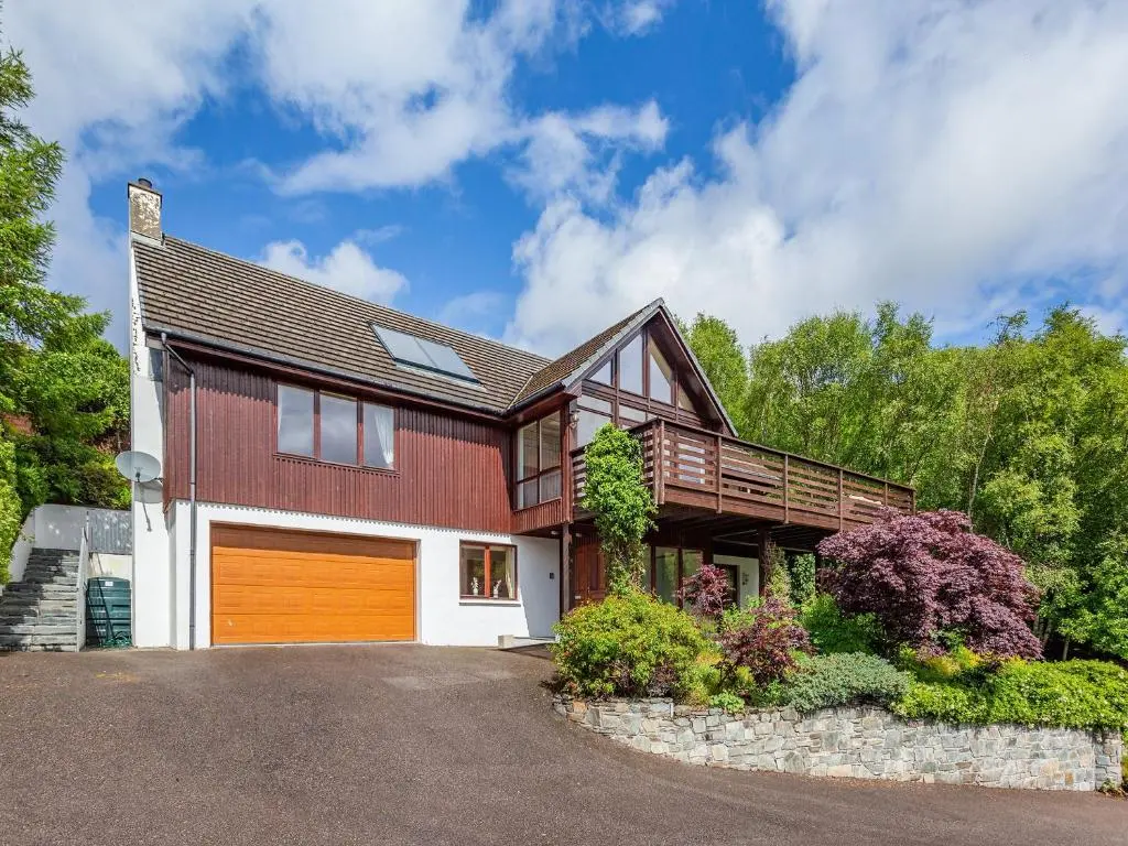 a house with a brown and white garage at Corrie Burn Villa in Ullapool