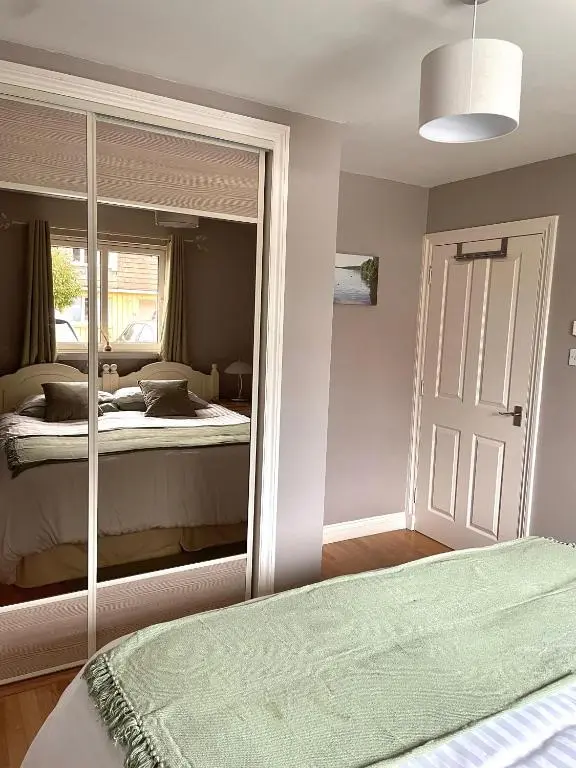 a bedroom with a bed and a large mirror at Birch Cottage in Aviemore