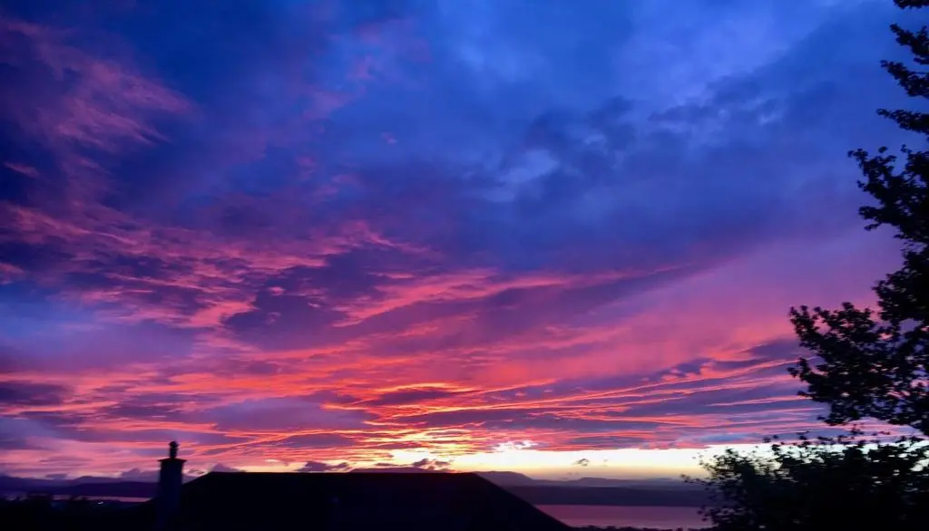 a sunset with a building in the foreground at By the Brae in Inverness