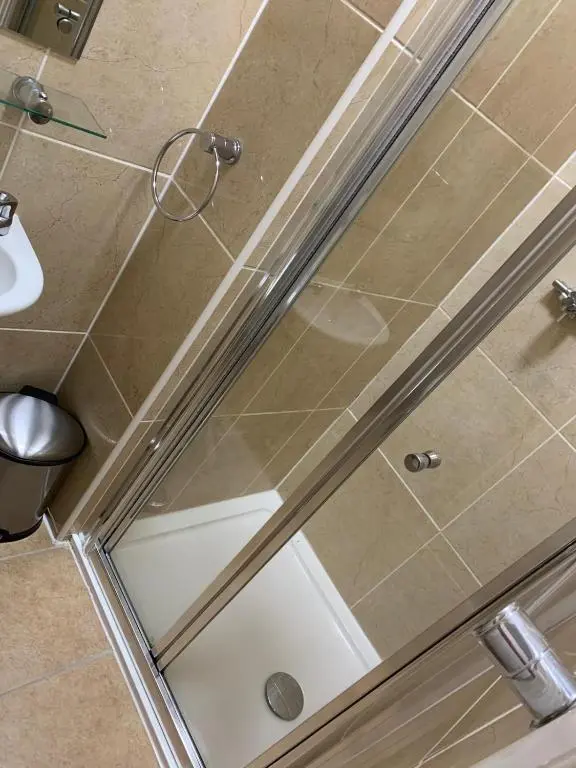 a shower with a glass door in a bathroom at Royal Hotel in Dingwall