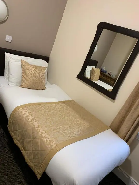 a bedroom with a bed and a mirror at Royal Hotel in Dingwall